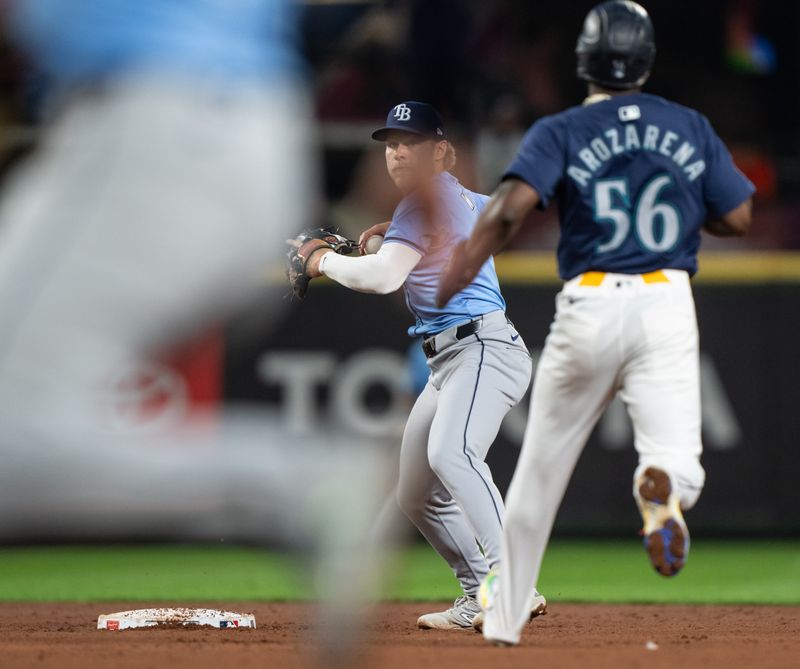 Aug 26, 2024; Seattle, Washington, USA; Tampa Bay Rays shortstop Taylor Walls (6) turns a double play after forcing out Seattle Mariners left fielder Randy Arozarena (56) during the fifth inning at T-Mobile Park. Mandatory Credit: Stephen Brashear-USA TODAY Sports