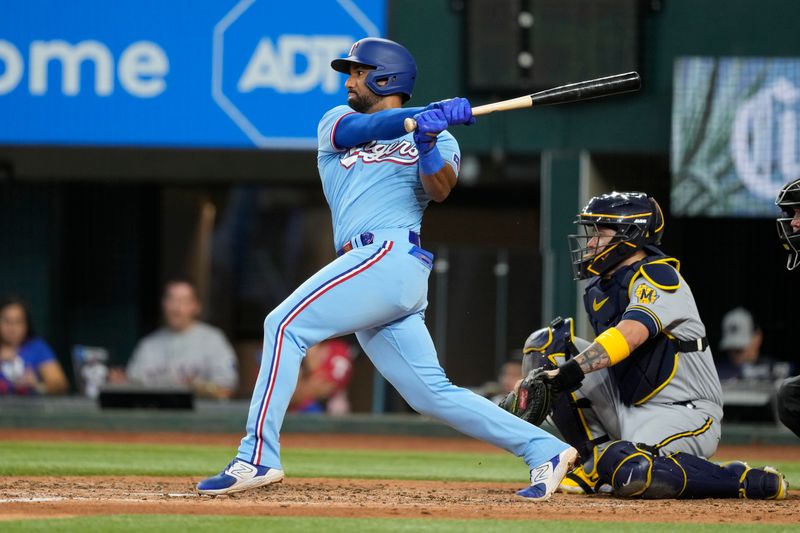 Aug 20, 2023; Arlington, Texas, USA; Texas Rangers third baseman Ezequiel Duran (20) follows through on his single against the Milwaukee Brewers during the fourth inning at Globe Life Field. Mandatory Credit: Jim Cowsert-USA TODAY Sports