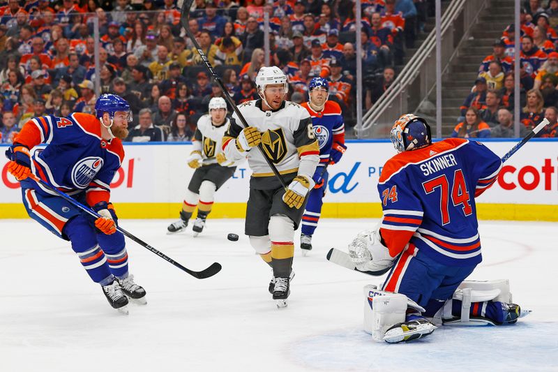 Apr 10, 2024; Edmonton, Alberta, CAN; Vegas Golden Knights forward Jonathan Marchessault (81) and Edmonton Oilers defensemen Mattias Ekholm (14) try to find a loose puck in front of goaltender Stuart Skinner (74) during the second period at Rogers Place. Mandatory Credit: Perry Nelson-USA TODAY Sports