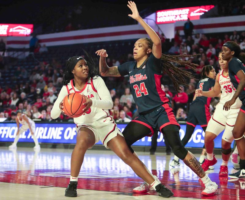 Jan 21, 2024; Athens, Georgia, USA; Georgia Bulldogs guard De   Mauri Flournoy (10) is defended by Ole Miss Rebels forward Madison Scott (24) during the second half at Stegeman Coliseum. Mandatory Credit: Mady Mertens-USA TODAY Sports