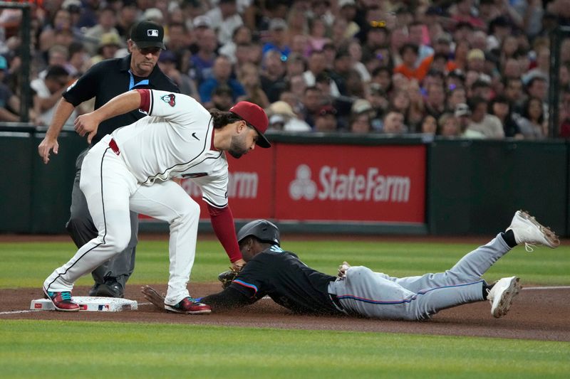 May 24, 2024; Phoenix, Arizona, USA; Miami Marlins outfielder Nick Gordon (1) gets tagged out trying to steal thirdbase by Arizona Diamondbacks third base Eugenio Suarez (28)in the fourth inning at Chase Field. Mandatory Credit: Rick Scuteri-USA TODAY Sports