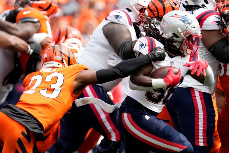 New England Patriots running back Rhamondre Stevenson (38) runs from Cincinnati Bengals cornerback Dax Hill (23) during the first half of an NFL football game, Sunday, Sept. 8, 2024, in Cincinnati. (AP Photo/Jeff Dean)