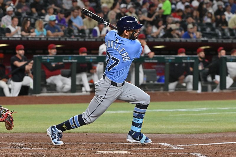 Apr 24, 2025; Phoenix, Arizona, USA;  Tampa Bay Rays shortstop JosÈ Caballero (77) hits an RBI double in the fifth inning against the Arizona Diamondbacks at Chase Field. Mandatory Credit: Matt Kartozian-Imagn Images
