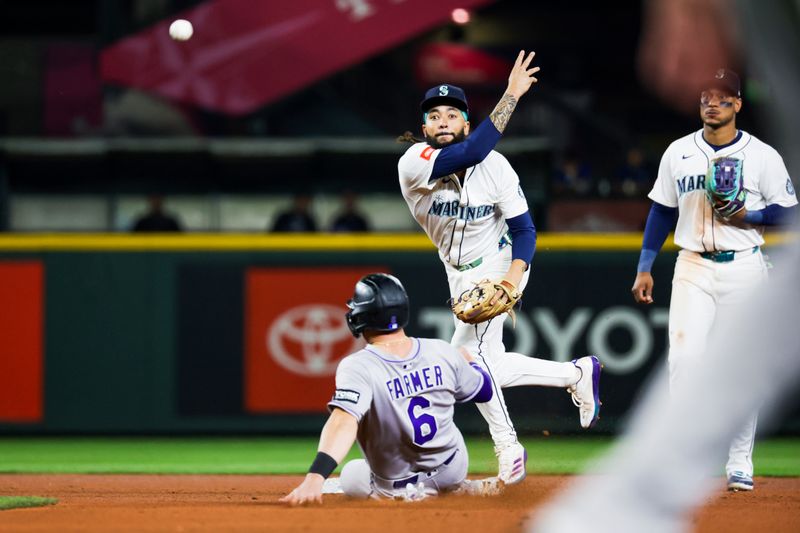 Sep 23, 2025; Seattle, Washington, USA; Seattle Mariners shortstop J.P. Crawford (3) turns a double play against the Colorado Rockies to end the top of the seventh inning at T-Mobile Park. Mandatory Credit: Joe Nicholson-Imagn Images