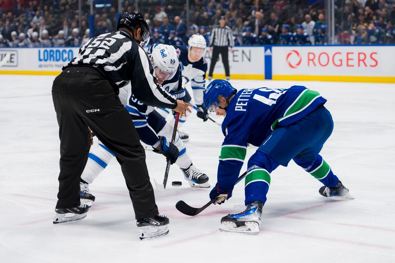 Mar 9, 2024; Vancouver, British Columbia, CAN; Vancouver Canucks forward Elias Pettersson (40) wins a face off draw against Winnipeg Jets forward Mark Scheifele (55) in the first period at Rogers Arena. Mandatory Credit: Bob Frid-USA TODAY Sports