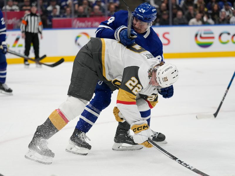 Nov 20, 2024; Toronto, Ontario, CAN; Toronto Maple Leafs forward Conor Dewar (24) battles with Vegas Golden Knights forward Cole Schwindt (22) during the second period at Scotiabank Arena. Mandatory Credit: John E. Sokolowski-Imagn Images