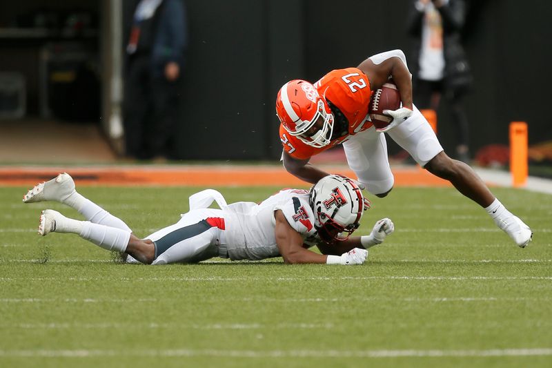 Nov 28, 2020; Oklahoma State Cowboys running back Dezmon Jackson (27) is brought down by Texas Tech Red Raiders defensive back Zech McPhearson (8) during a football game at Boone Pickens Stadium. Mandatory Credit: Bryan Terry-USA TODAY Sports