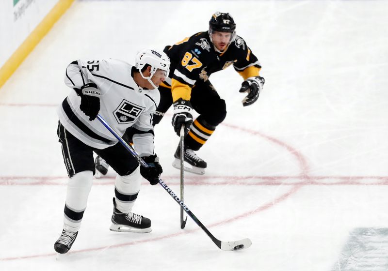 Feb 18, 2024; Pittsburgh, Pennsylvania, USA;  Los Angeles Kings defenseman Quentin Byfield moves the puck against Pittsburgh Penguins center Sidney Crosby (87) during the second period at PPG Paints Arena. Mandatory Credit: Charles LeClaire-USA TODAY Sports