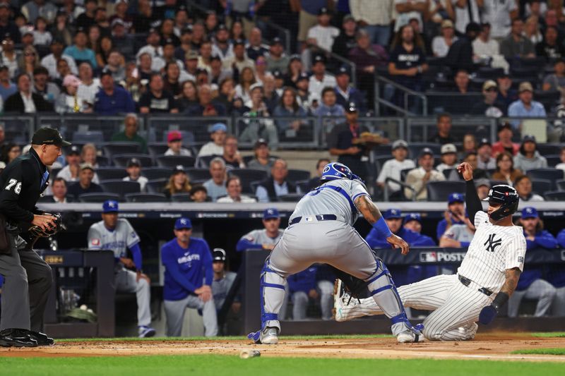 Oct 5, 2024; Bronx, New York, USA; New York Yankees second base Gleyber Torres (25) is tagged out by Kansas City Royals catcher Salvador Perez (13) during the second inning during game one of the ALDS for the 2024 MLB Playoffs at Yankee Stadium. Mandatory Credit: Vincent Carchietta-Imagn Images