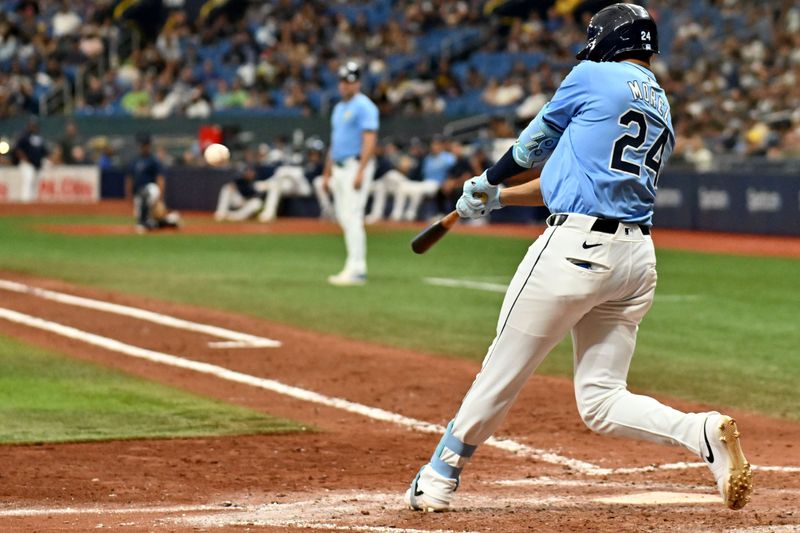 Sep 22, 2024; St. Petersburg, Florida, USA; Tampa Bay Rays pinch hitter Christopher Morel (24) drives in a run with a sacrifice fly in the seventh inning against the Toronto Blue Jays at Tropicana Field. Mandatory Credit: Jonathan Dyer-Imagn Images