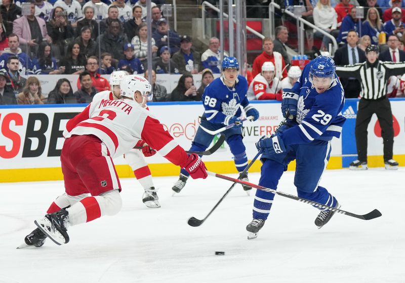 Apr 13, 2024; Toronto, Ontario, CAN; Toronto Maple Leafs right wing Pontus Holmberg (29) tries to handle the puck as Detroit Red Wings defenseman Olli Maatta (2) defends during the third period at Scotiabank Arena. Mandatory Credit: Nick Turchiaro-USA TODAY Sports