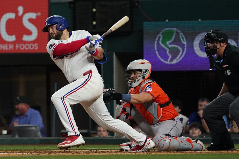 May 15, 2025; Arlington, Texas, USA; Texas Rangers first baseman Jake Burger (21) hits a single during the eighth inning against the Houston Astros at Globe Life Field. Mandatory Credit: Raymond Carlin III-Imagn Images