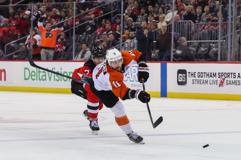 Jan 18, 2025; Newark, New Jersey, USA; Philadelphia Flyers right wing Travis Konecny (11) scores an empty net goal against the New Jersey Devils during the third period at Prudential Center. Mandatory Credit: Ed Mulholland-Imagn Images