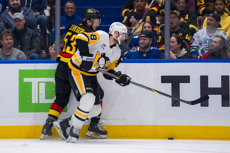 Oct 26, 2024; Vancouver, British Columbia, CAN;  Pittsburgh Penguins defenseman Marcus Pettersson (28) checks Vancouver Canucks forward Teddy Blueger (53) during the third period at Rogers Arena. Mandatory Credit: Bob Frid-Imagn Images