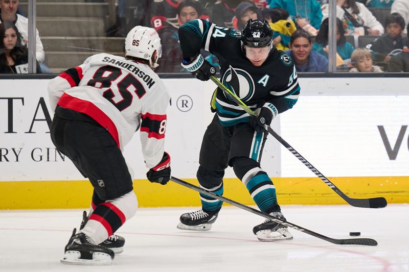 Mar 9, 2024; San Jose, California, USA; San Jose Sharks center Mikael Granlund (64) plays the puck against Ottawa Senators defenseman Jake Sanderson (85) during the second period at SAP Center at San Jose. Mandatory Credit: Robert Edwards-USA TODAY Sports