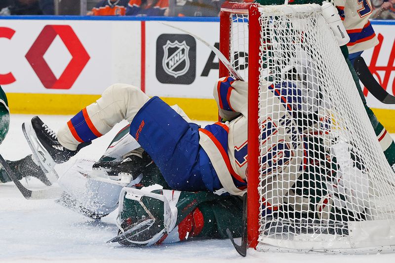 Jan 31, 2026; Edmonton, Alberta, CAN; Edmonton Oilers forward Zach Hyman (18) runs over Minnesota Wild goaltender Jesper Wallstedt (30) during the first period at Rogers Place. Mandatory Credit: Perry Nelson-Imagn Images