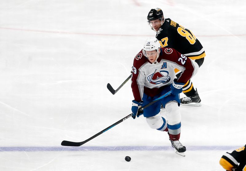 Oct 26, 2023; Pittsburgh, Pennsylvania, USA; Colorado Avalanche center Nathan MacKinnon (29) moves the puck ahead of Pittsburgh Penguins center Sidney Crosby (87) during the second period at PPG Paints Arena. Mandatory Credit: Charles LeClaire-USA TODAY Sports