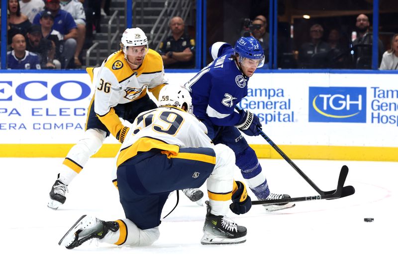 Oct 28, 2024; Tampa, Florida, USA; Tampa Bay Lightning center Brayden Point (21) passes the puck as Nashville Predators defenseman Roman Josi (59) and left wing Cole Smith (36) defied during the first period at Amalie Arena. Mandatory Credit: Kim Klement Neitzel-Imagn Images