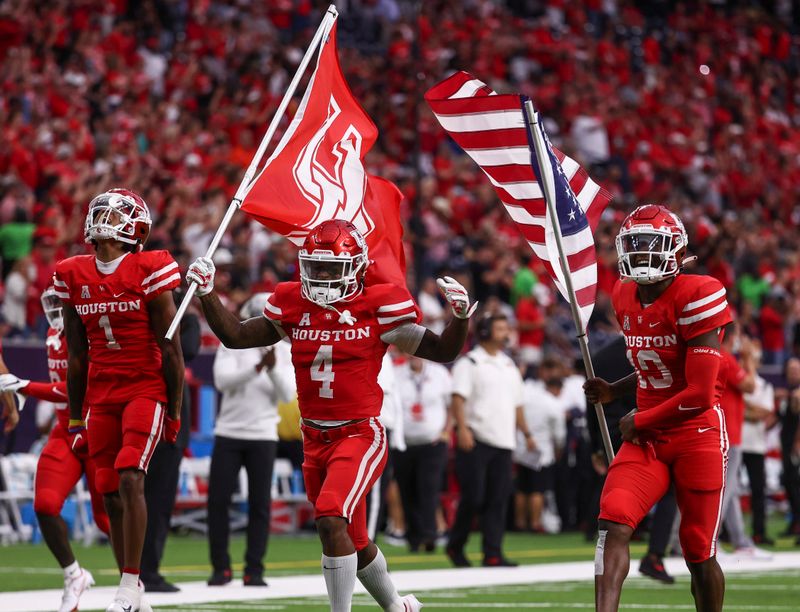 Sep 4, 2021; Houston, Texas, USA; Houston Cougars players run onto the field with flags before a game against the Texas Tech Red Raiders at NRG Stadium. Mandatory Credit: Troy Taormina-USA TODAY Sports