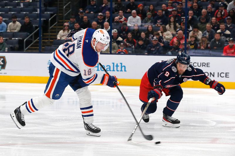 Oct 28, 2024; Columbus, Ohio, USA; Edmonton Oilers center Zach Hyman (18) shoots as Columbus Blue Jackets defenseman Ivan Provorov (9) defends during the first period at Nationwide Arena. Mandatory Credit: Russell LaBounty-Imagn Images