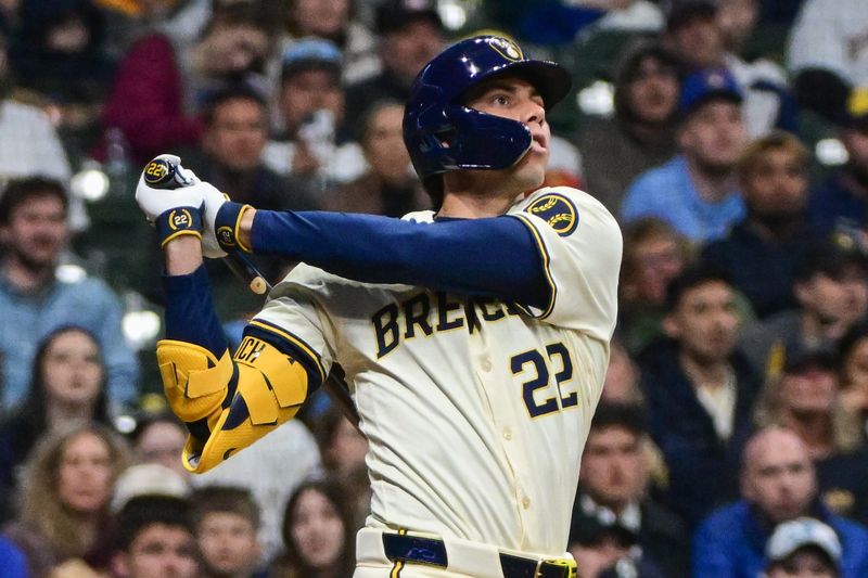 Apr 5, 2024; Milwaukee, Wisconsin, USA; Milwaukee Brewers left fielder Christian Yelich (22) hits a solo home run in the sixth inning as Seattle Mariners catcher Cal Raleigh (29) looks on at American Family Field. Mandatory Credit: Benny Sieu-USA TODAY Sports