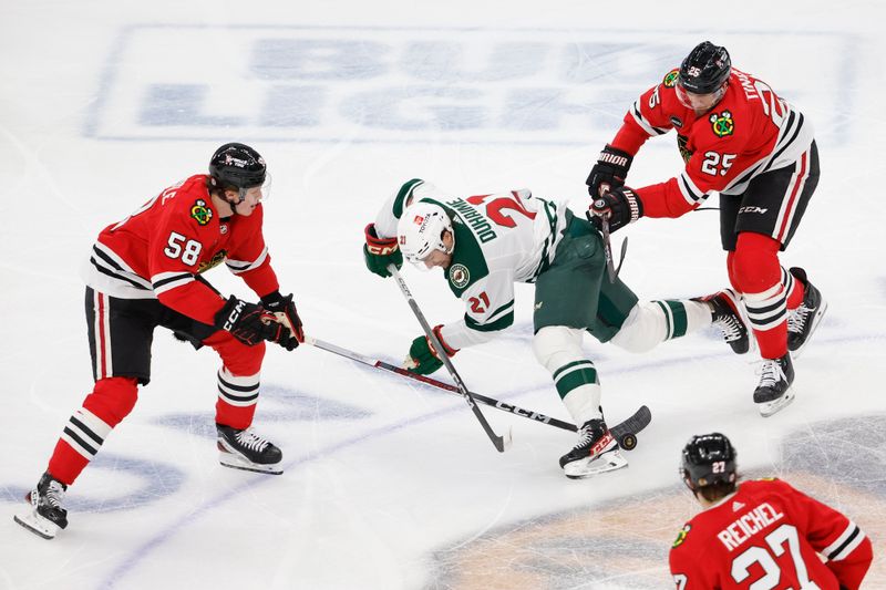 Feb 7, 2024; Chicago, Illinois, USA; Minnesota Wild right wing Brandon Duhaime (21) battles for the puck with Chicago Blackhawks right wing MacKenzie Entwistle (58) during the second period at United Center. Mandatory Credit: Kamil Krzaczynski-USA TODAY Sports