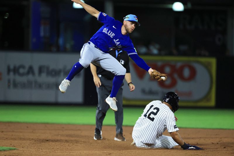 Mar 11, 2026; Tampa, Florida, USA;  Toronto Blue Jays infielder Rafael Lantigua (72) attempted to tag out New York Yankees center fielder Trent Grisham (12) as he stole second base during the fifth inning at George M. Steinbrenner Field. Mandatory Credit: Kim Klement Neitzel-Imagn Images
