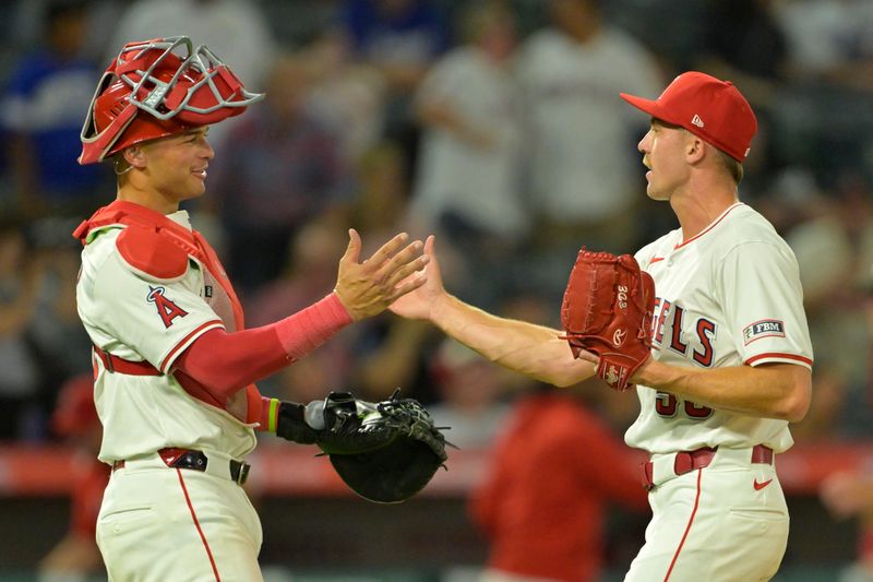 Sep 4, 2024; Anaheim, California, USA;  Los Angeles Angels catcher Logan O'Hoppe (14) shakes hands with relief pitcher Ryan Miller (53) after the final out of the ninth inning defeating the Los Angeles Dodgers at Angel Stadium. Mandatory Credit: Jayne Kamin-Oncea-Imagn Images