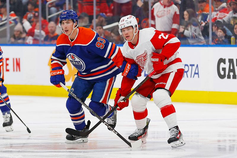 Feb 13, 2024; Edmonton, Alberta, CAN; Edmonton Oilers forward Ryan Nugent-Hopkins (93) and Detroit Red Wings forward Lucas Raymond (23) look for a loose puck during the first period at Rogers Place. Mandatory Credit: Perry Nelson-USA TODAY Sports