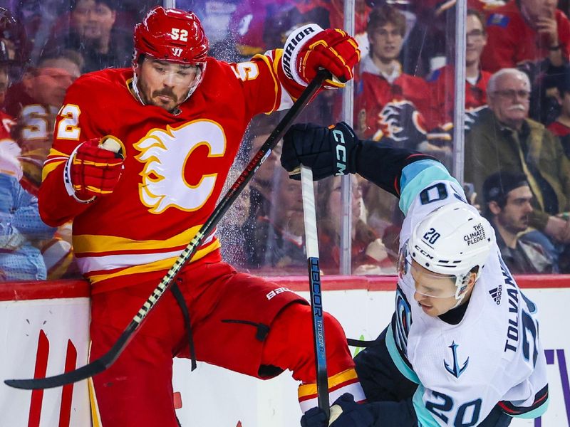 Dec 27, 2023; Calgary, Alberta, CAN; Calgary Flames defenseman MacKenzie Weegar (52) and Seattle Kraken right wing Eeli Tolvanen (20) battle for the puck during the third period at Scotiabank Saddledome. Mandatory Credit: Sergei Belski-USA TODAY Sports