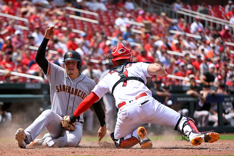 Jun 14, 2023; St. Louis, Missouri, USA;  San Francisco Giants designated hitter Wilmer Flores (41) slides salty past the tag of St. Louis Cardinals catcher Andrew Knizner (7) during the tenth inning at Busch Stadium. Mandatory Credit: Jeff Curry-USA TODAY Sports