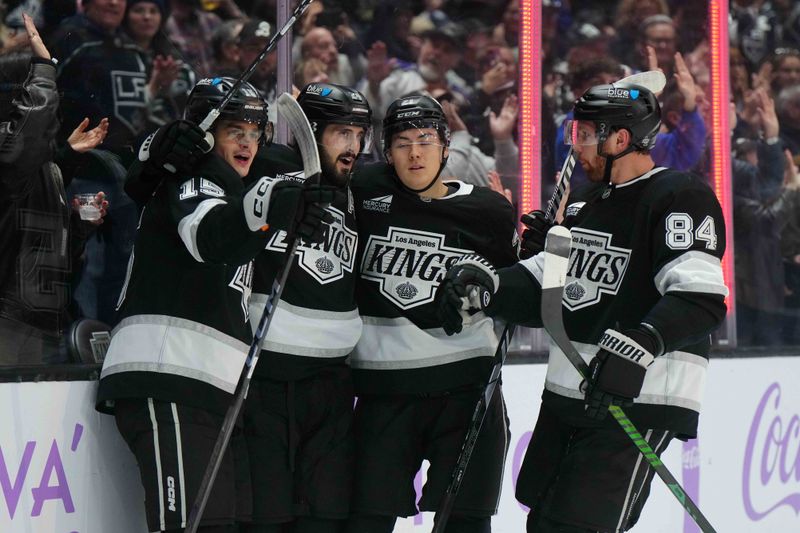 Nov 27, 2024; Los Angeles, California, USA; LA Kings center Alex Turcotte (15), defenseman Jordan Spence (21), center Phillip Danault (24) and defenseman Vladislav Gavrikov (84) celebrate after a goal against the Winnipeg Jets in the second period at Crypto.com Arena. Mandatory Credit: Kirby Lee-Imagn Images