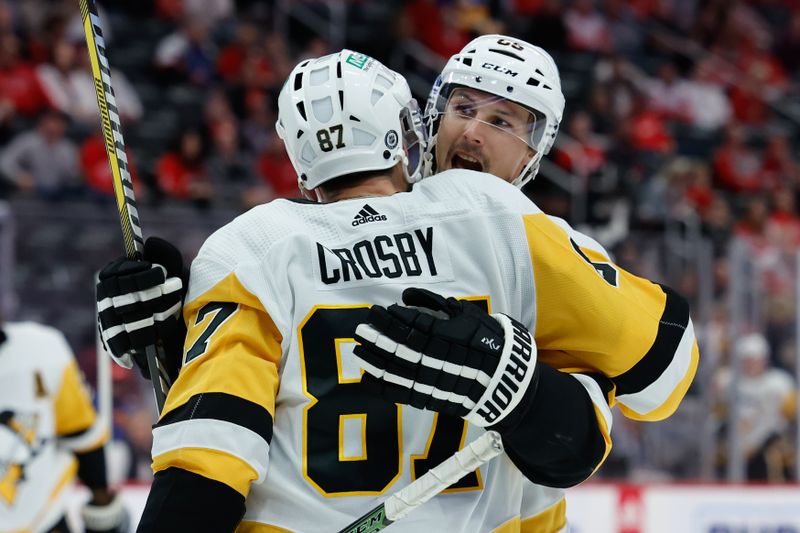 Oct 18, 2023; Detroit, Michigan, USA; Pittsburgh Penguins defenseman Erik Karlsson (65) receives congratulations from center Sidney Crosby (87) after scoring in the third period at Little Caesars Arena. Mandatory Credit: Rick Osentoski-USA TODAY Sports