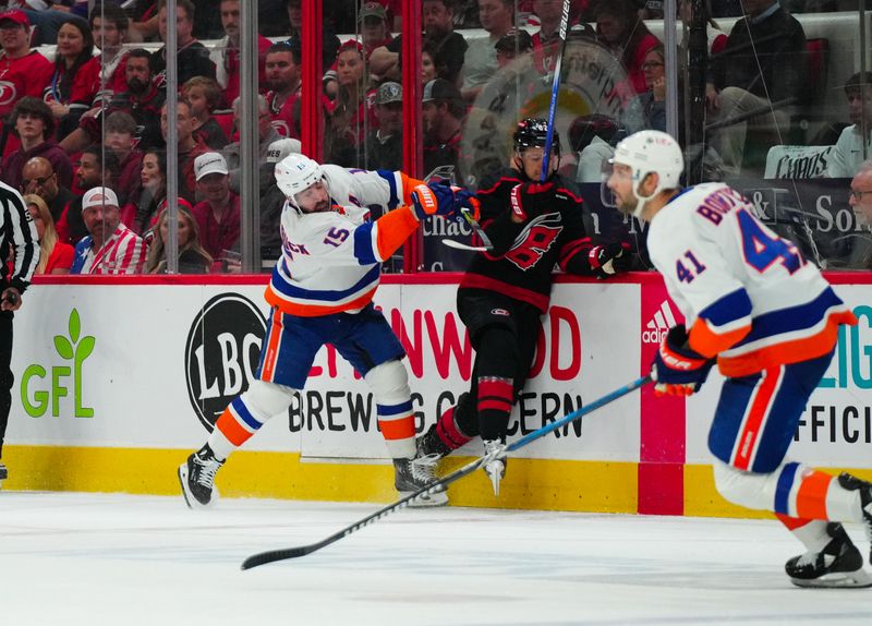 Apr 30, 2024; Raleigh, North Carolina, USA; New York Islanders right wing Cal Clutterbuck (15) checks Carolina Hurricanes center Jesperi Kotkaniemi (82) during the first period in game five of the first round of the 2024 Stanley Cup Playoffs at PNC Arena. Mandatory Credit: James Guillory-USA TODAY Sports