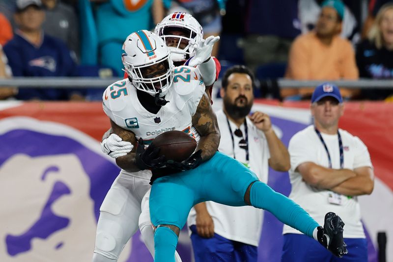 Miami Dolphins cornerback Xavien Howard (25) intercepts a pass intended for New England Patriots wide receiver DeVante Parker (1) during the second half of an NFL football game, Sunday, Sept. 17, 2023, in Foxborough, Mass. (AP Photo/Michael Dwyer)