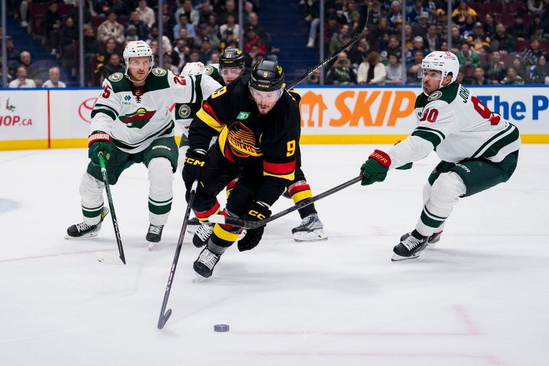 Dec 7, 2023; Vancouver, British Columbia, CAN; Minnesota Wild defenseman Jonas Brodin (25) watches as forward Marcus Johansson (90) stick checks Vancouver Canucks forward J.T. Miller (9) in the first period at Rogers Arena. Mandatory Credit: Bob Frid-USA TODAY Sports