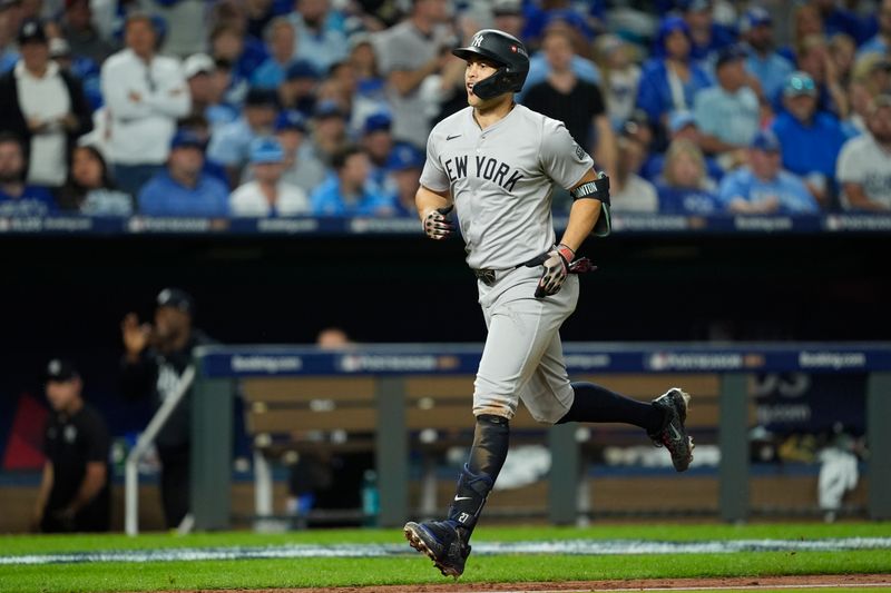 Oct 9, 2024; Kansas City, Missouri, USA; New York Yankees designated hitter Giancarlo Stanton (27) hits a home run in the eighth inning against the Kansas City Royals during game three of the NLDS for the 2024 MLB Playoffs at Kauffman Stadium. Mandatory Credit: Jay Biggerstaff -Imagn Images