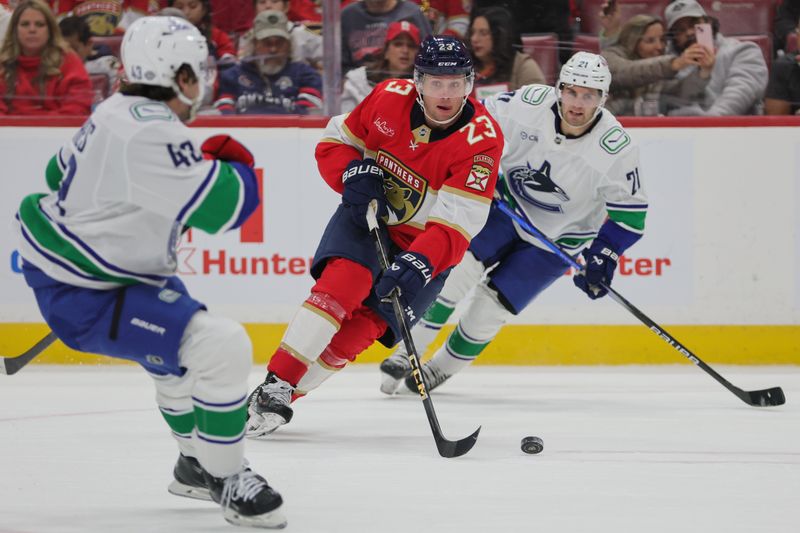 Oct 17, 2024; Sunrise, Florida, USA; Florida Panthers center Carter Verhaeghe (23) moves the puck against the Vancouver Canucks during the first period at Amerant Bank Arena. Mandatory Credit: Sam Navarro-Imagn Images