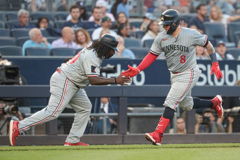 Jun 6, 2024; Bronx, New York, USA;  Minnesota Twins catcher Christian Vazquez (8) celebrates his solo home run with third base coach coach Tommy Watkins (40) during the third inning against the New York Yankees at Yankee Stadium. Mandatory Credit: Vincent Carchietta-USA TODAY Sports