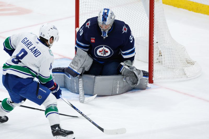 Apr 18, 2024; Winnipeg, Manitoba, CAN;  Winnipeg Jets goalie Laurent Boissoit (39) stops Vancouver Canucks forward Conor Garland (8) during the third period at Canada Life Centre. Mandatory Credit: Terrence Lee-USA TODAY Sports