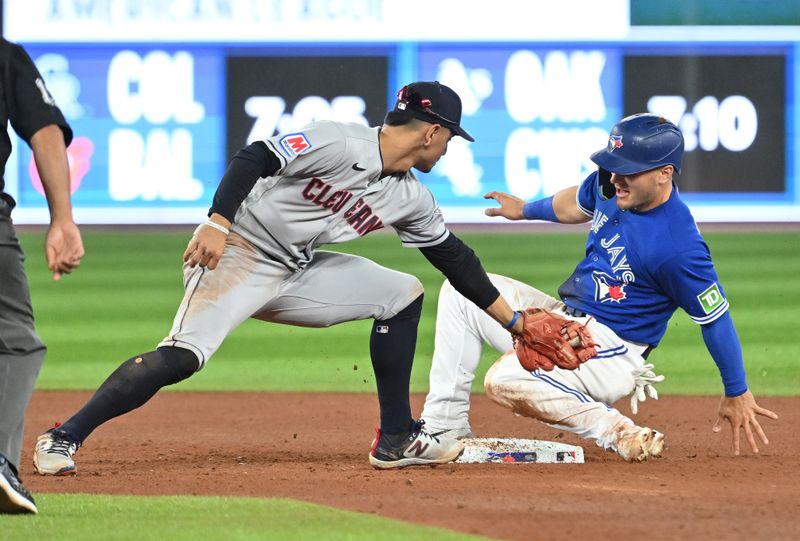 Aug 26, 2023; Toronto, Ontario, CAN;  Toronto Blue Jays center fielder Daulton Varsho (25) is tagged out while trying to steal second base against Cleveland Guardians second baseman Andres Gimenez (0) in the seventh inning at Rogers Centre. Mandatory Credit: Dan Hamilton-USA TODAY Sports