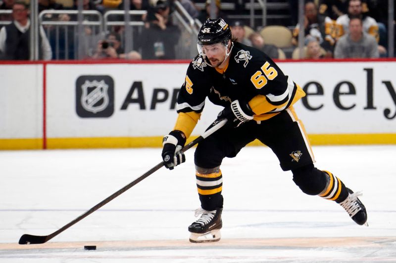 Jan 11, 2024; Pittsburgh, Pennsylvania, USA; Pittsburgh Penguins defenseman Erik Karlsson (65) skates up ice with the puck against the Vancouver Canucks during the third period at PPG Paints Arena. The Canucks won 4-3 in overtime. Mandatory Credit: Charles LeClaire-USA TODAY Sports