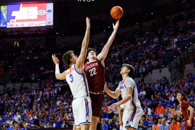 Dec 21, 2025; Gainesville, Florida, USA; Colgate Raiders forward Andrew Alekseyenko (22) attempts a layup over Florida Gators center Micah Handlogten (3) and Florida Gators forward Alex Condon (21) during the first half at Exactech Arena at the Stephen C. O'Connell Center. Mandatory Credit: Matt Pendleton-Imagn Images