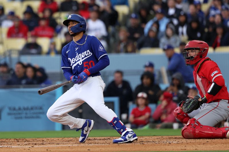 Mar 24, 2024; Los Angeles, California, USA;  Los Angeles Dodgers second baseman Mookie Betts (50) hits a double during the second inning against the Los Angeles Angels at Dodger Stadium. Mandatory Credit: Kiyoshi Mio-USA TODAY Sports