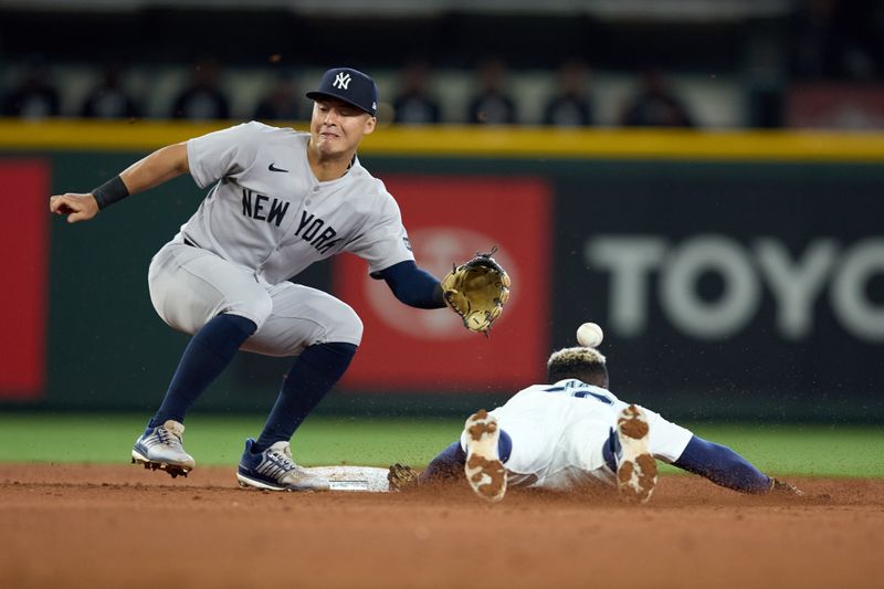 May 14, 2025; Seattle, Washington, USA; Seattle Mariners left fielder Randy Arozarena (56) steals second as the ball flys past New York Yankees shortstop Anthony Volpe (11) during the fourth inning at T-Mobile Park. Mandatory Credit: John Froschauer-Imagn Images
