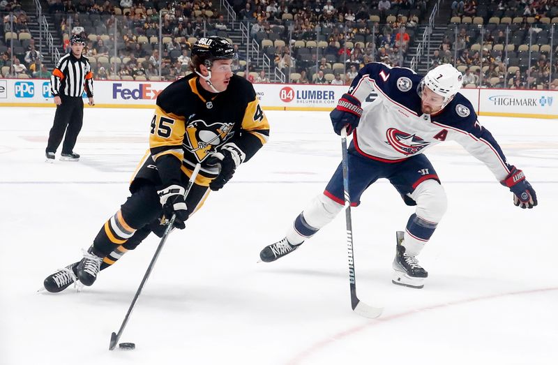 Oct 4, 2024; Pittsburgh, Pennsylvania, USA;  Pittsburgh Penguins defenseman Harrison Brunicke (45) skates in on goal against Columbus Blue Jackets center Sean Kuraly (7) during the first period at PPG Paints Arena. Mandatory Credit: Charles LeClaire-Imagn Images