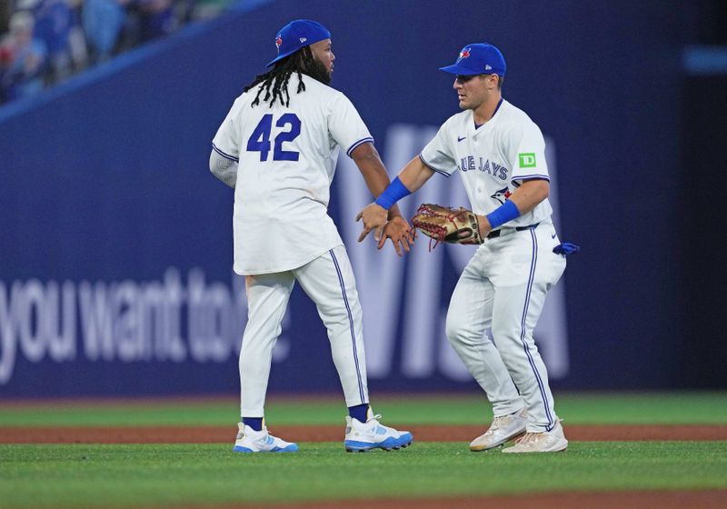 Apr 15, 2024; Toronto, Ontario, CAN; Toronto Blue Jays first base Vladimir Guerrero Jr. celebrates the win with left fielder Daulton Varsho all wearing number 42 for Jackie Robinson Day at the end of the ninth inning against the New York Yankees at Rogers Centre. Mandatory Credit: Nick Turchiaro-USA TODAY Sports