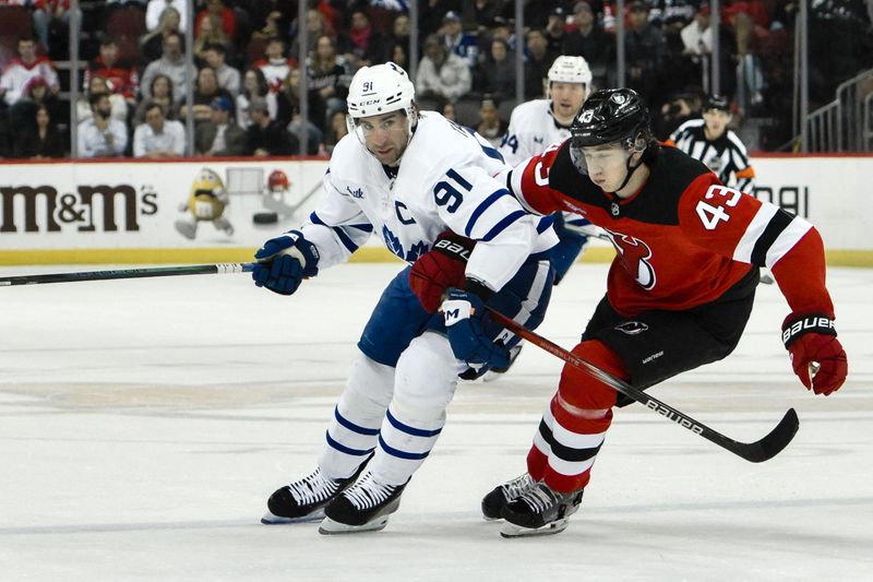 Apr 9, 2024; Newark, New Jersey, USA; Toronto Maple Leafs center John Tavares (91) tries to get past New Jersey Devils defenseman Luke Hughes (43) during the first period at Prudential Center. Mandatory Credit: John Jones-USA TODAY Sports