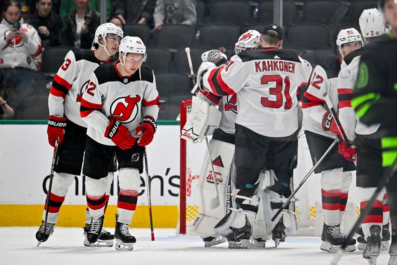 Mar 14, 2024; Dallas, Texas, USA; New Jersey Devils defenseman Luke Hughes (43) and center Curtis Lazar (42) and goaltender Jake Allen (34) and goaltender Kaapo Kahkonen (31) celebrate on the ice after the Devils defeat the Dallas Stars at the American Airlines Center. Mandatory Credit: Jerome Miron-USA TODAY Sports