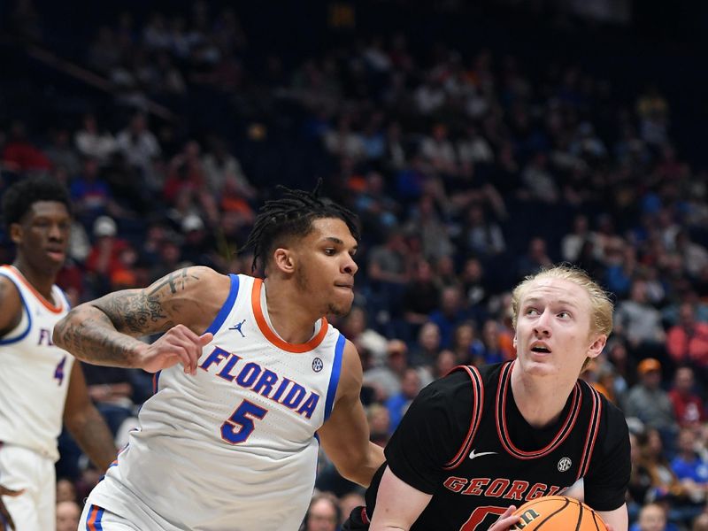 Mar 14, 2024; Nashville, TN, USA; Georgia Bulldogs guard Blue Cain (0) works in the lane against Florida Gators guard Will Richard (5) during the second half at Bridgestone Arena. Mandatory Credit: Christopher Hanewinckel-USA TODAY Sports